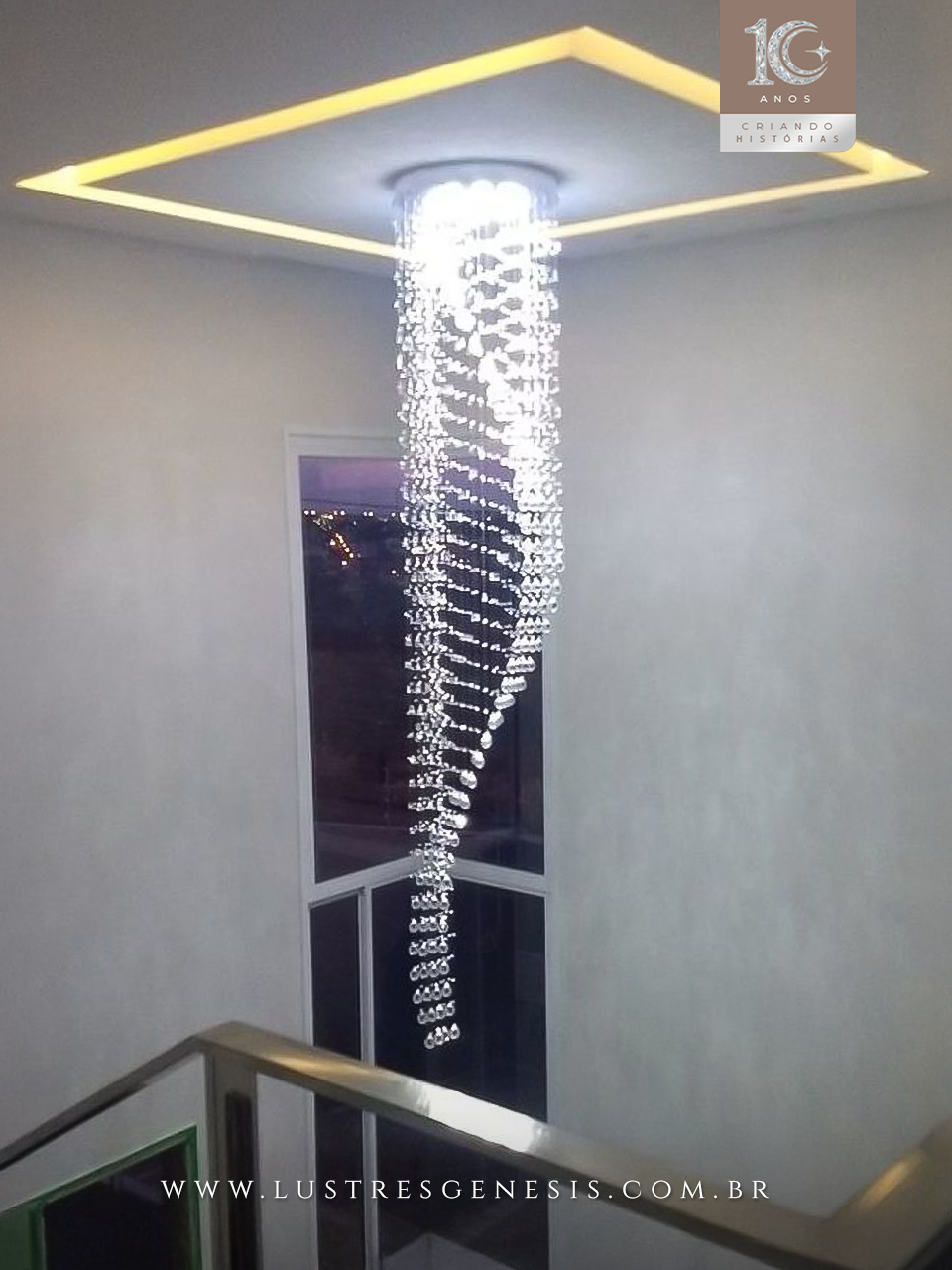 Lustre de cristal design S Rico instalado em sala com pé direito duplo, destacando cristais K9 legítimos da Linha Kria, ideal para ambientes sofisticados.